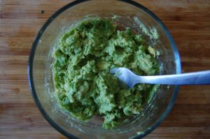 avocado smashing guacamole