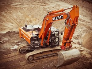 orange kliemt excavator digging on brown soil