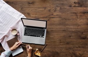 person holding chocolate bar near laptop space