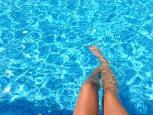 person feet dipping on pool space