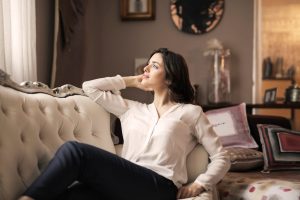 woman in white dress shirt and black pants lounging at home