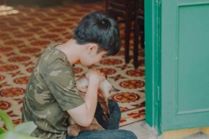 photo of boy wearing camouflage shirt holding a cat hvac system