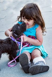 black dog beside little girl